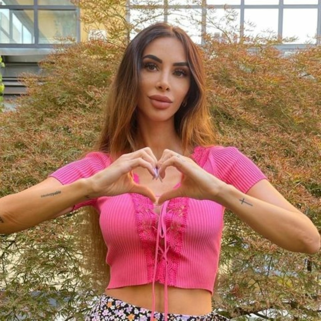 Influencerin Ilaria Fasolo formt mit ihren Händen ein Herz und setzt damit ein Zeichen im Kampf gegen Brustkrebs.