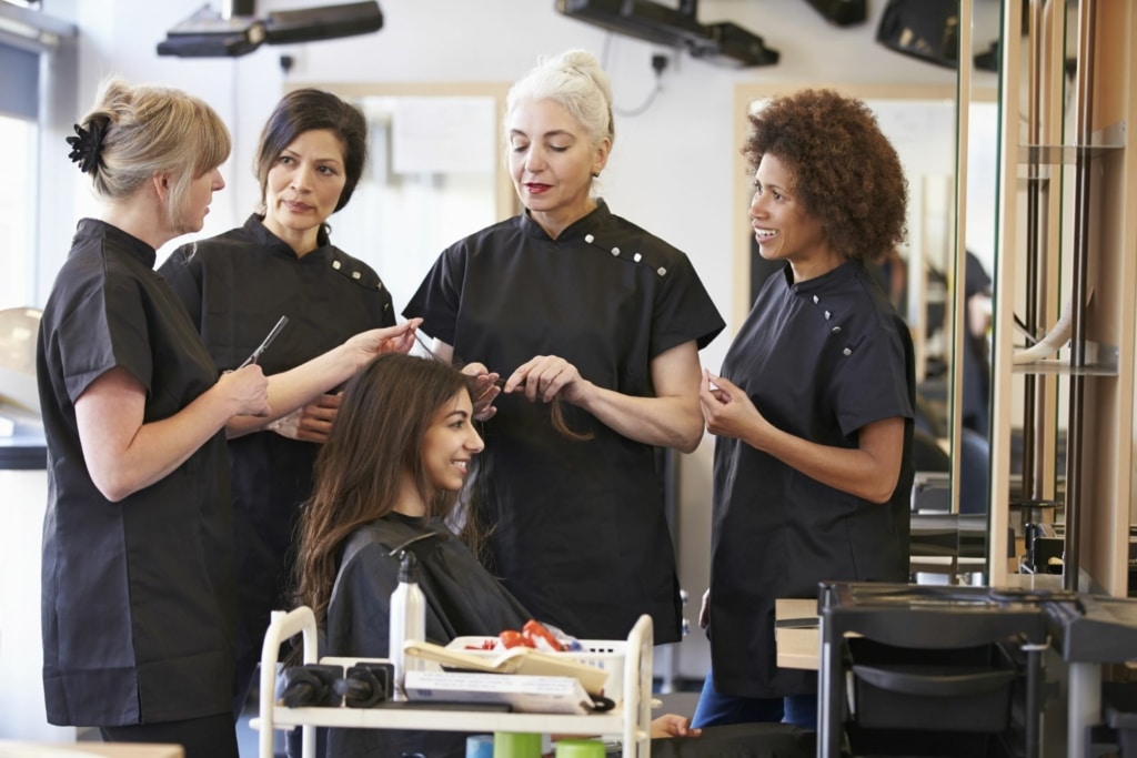 Een Hairdreams trainer demonstreert hoe hairstyling werkt in de Hairdreams Academy.
