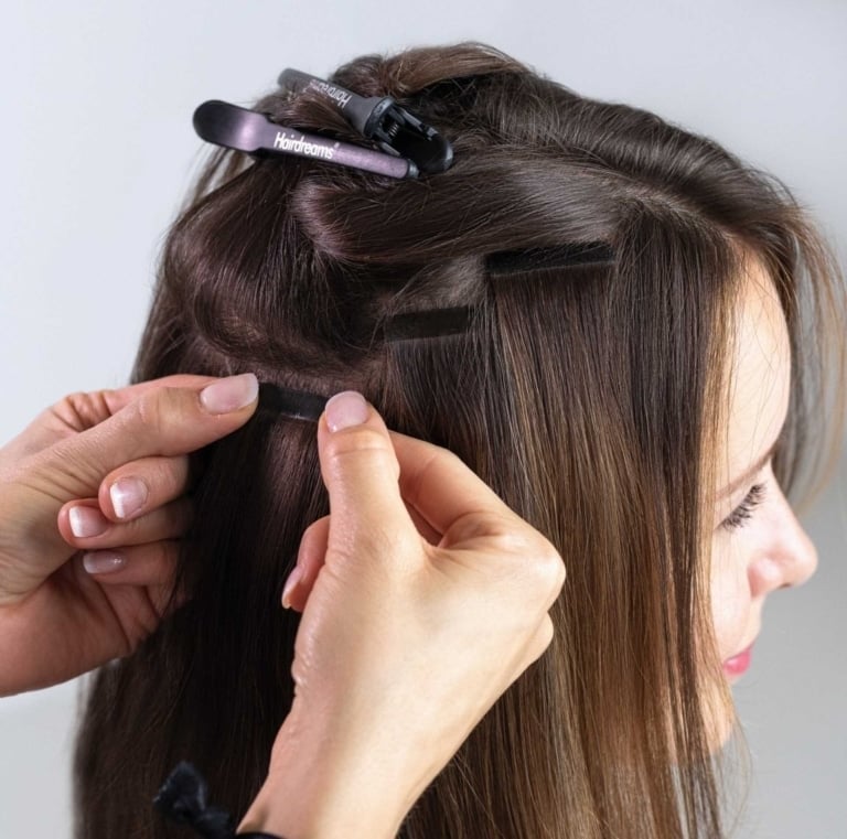 Tape-Extensions werden am Eigenhaar der Kundin befestigt